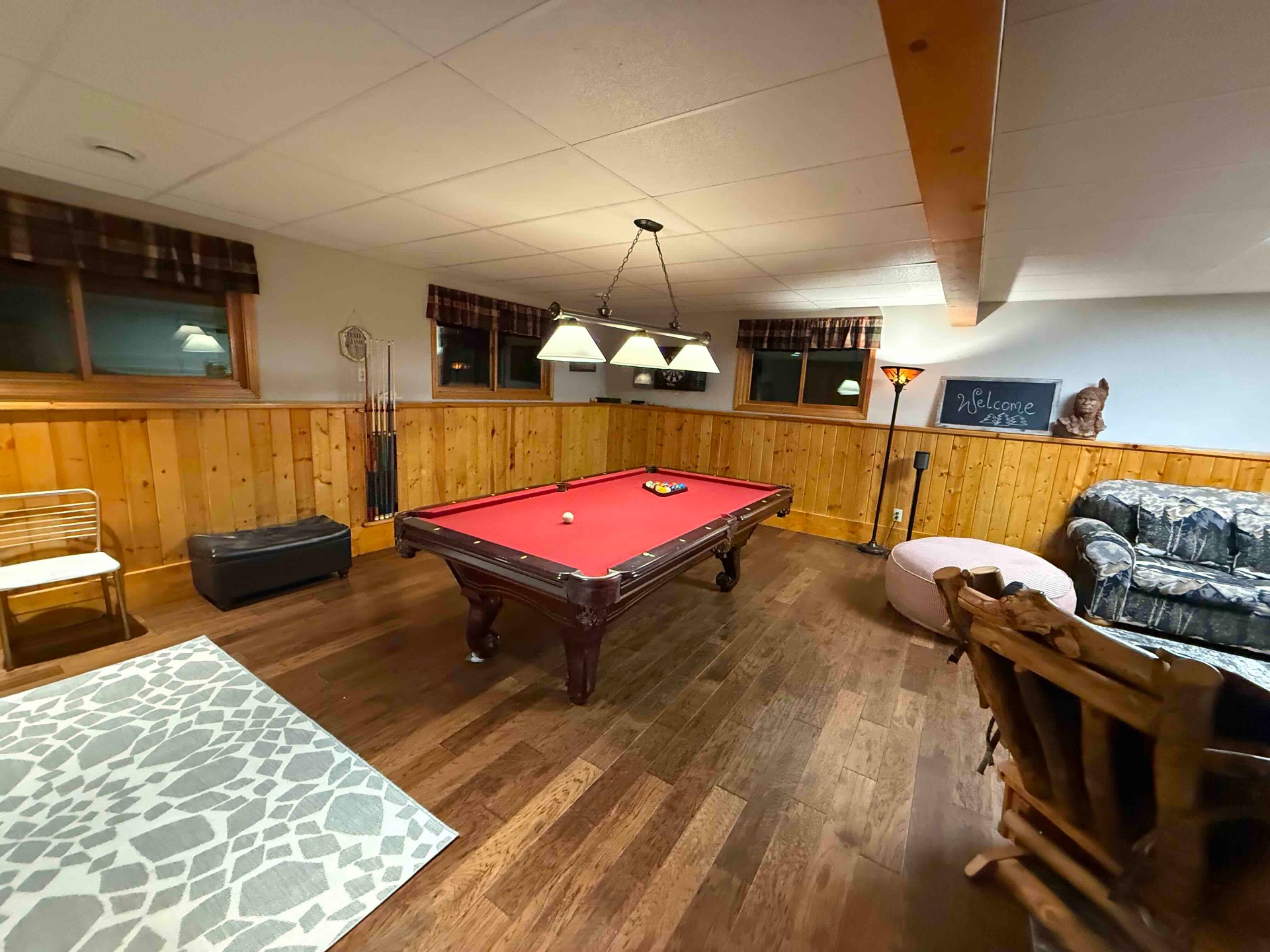 Downstairs game room with pool table and knotty pine walls