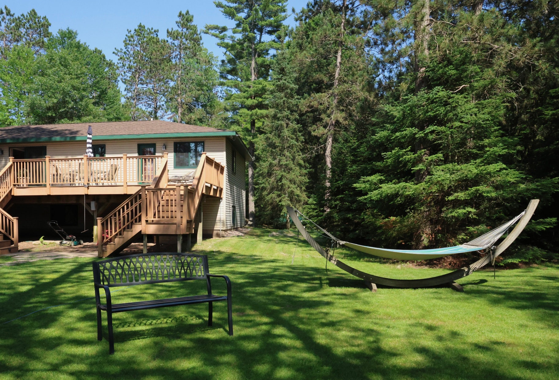 Backyard hammock and bench with the lodge and pines behind