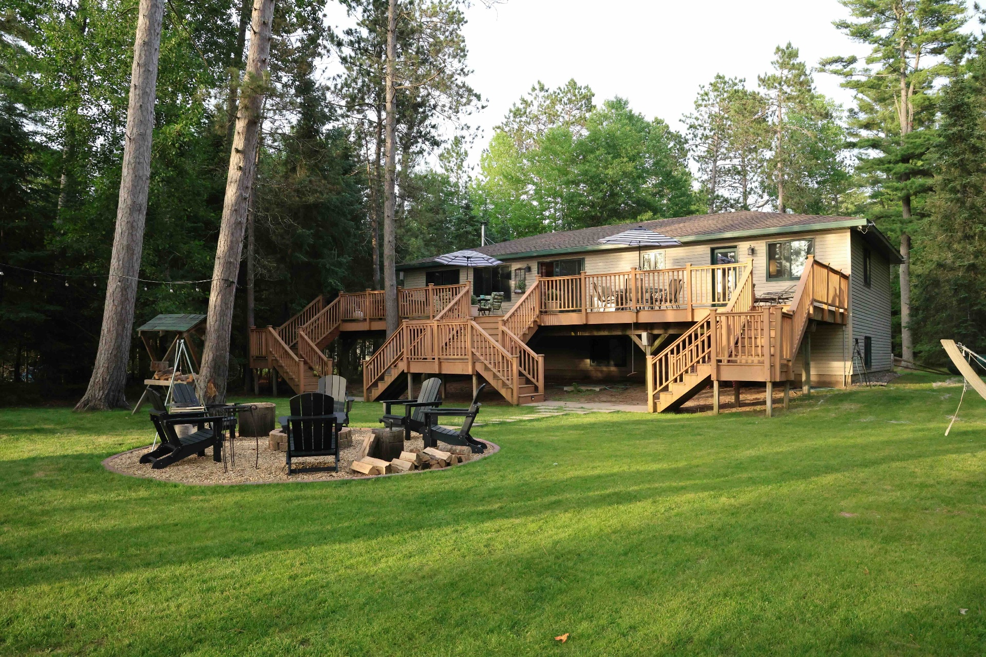 Lodge exterior from the yard with multi-level decks and fire pit