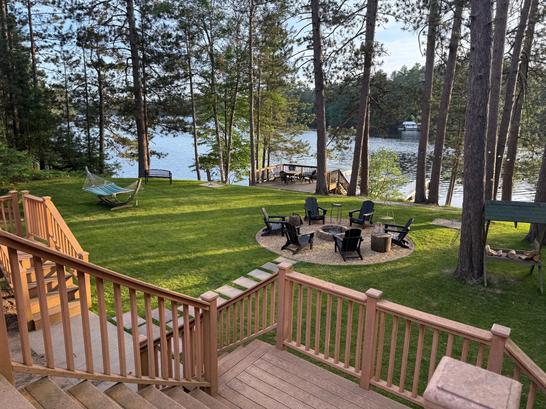 View from the upper deck down to the fire pit, hammock, and lake