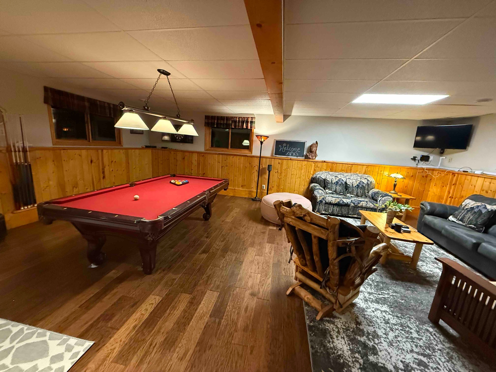 Game room lounge with pool table, TV, and log furniture